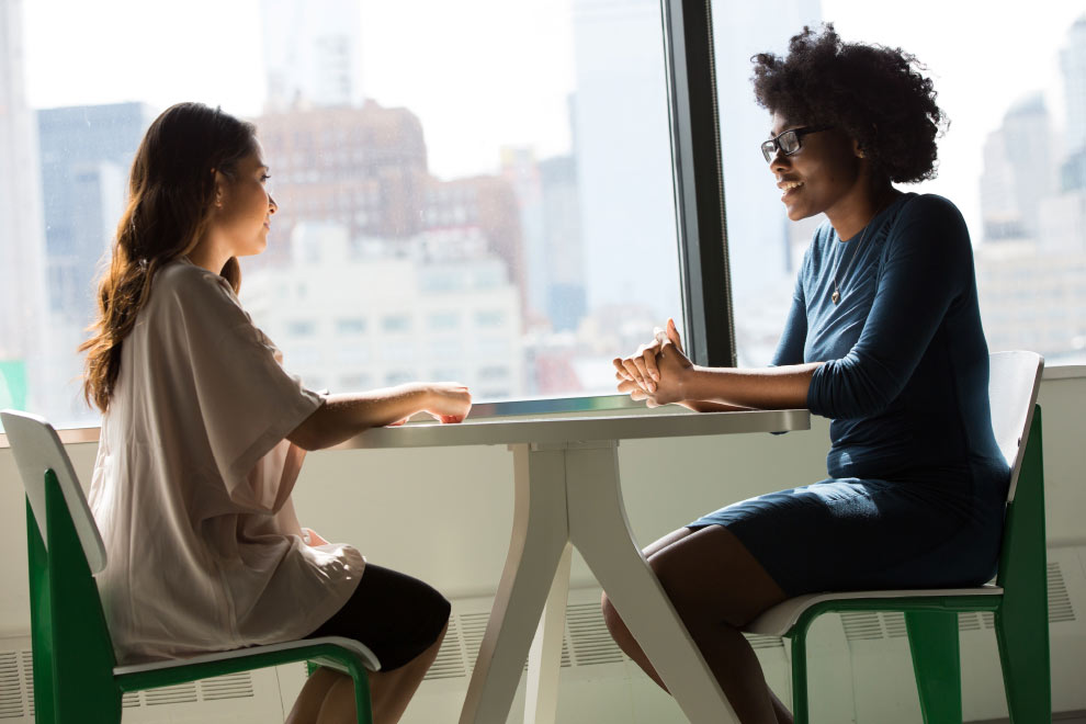 Two woman sitting at table